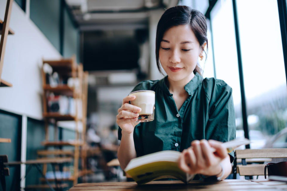 a woman reading a book in a cafe