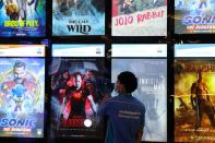 A cleaner wearing a protective face mask and gloves cleans the movies screen board at Mall of the Emirates during the reopening of malls, following the outbreak of the coronavirus disease (COVID-19), in Dubai