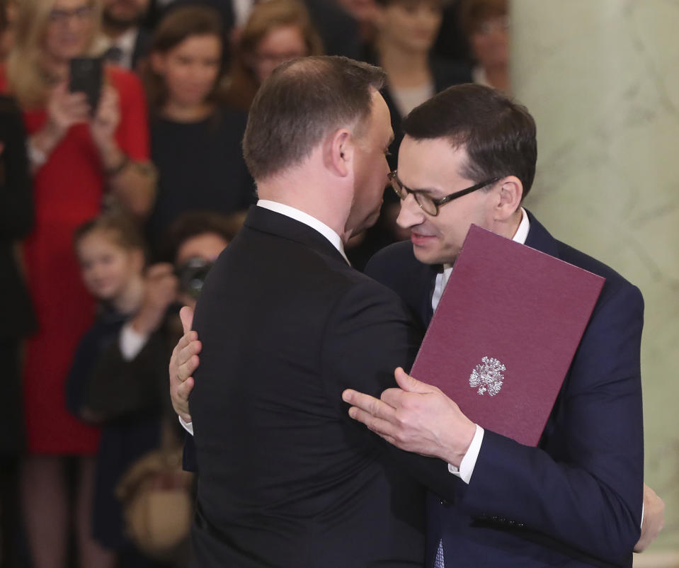 Poland's President Andrzej Duda,right, takes the oath of office from Prime Minister Mateusz Morawiecki and members of the new government that Morawiecki formed, following last month's election that gave the ruling right-wing Law and Justice party a second term in power, at the Presidential Palace in Warsaw, Poland, Friday, Nov. 15, 2019. Morawiecki and his Cabinet still need approval from the parliament, expected next week. (AP Photo/Czarek Sokolowski)