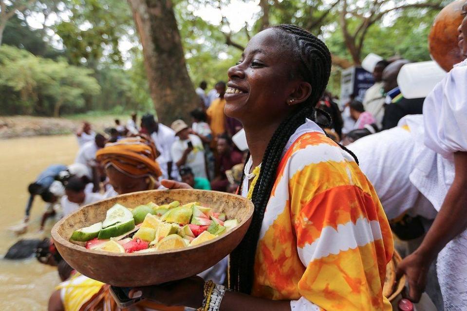 A worshipper of Osun prays with an offering in a calabash at bank of the Osun River during the Osun annual festival at the Osun-Osogbo Sacred Grove in Osogbo, southwest Nigeria, August 9, 2024.