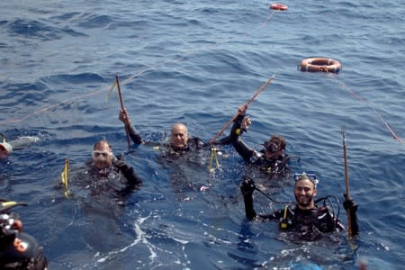 Divers prepare to dive to catch lionfish at the Zenobia, a cargo ship wreck off Larnaca