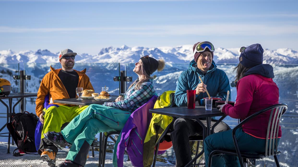  Group of friends enjoying apres-ski at top of Whistler mountain. 