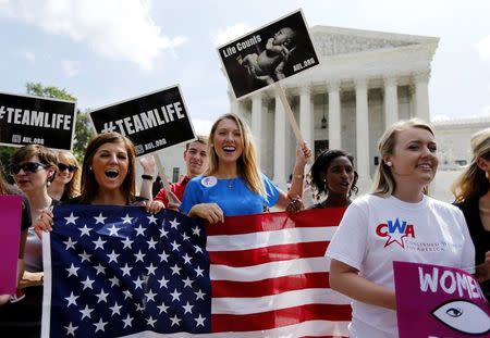 Anti-abortion protestors celebrate the U.S. Supreme Court's ruling striking down a Massachusetts law that mandated a protective buffer zone around abortion clinics, as the demonstrators stand outside the Court in Washington June 26, 2014. REUTERS/Jim Bourg