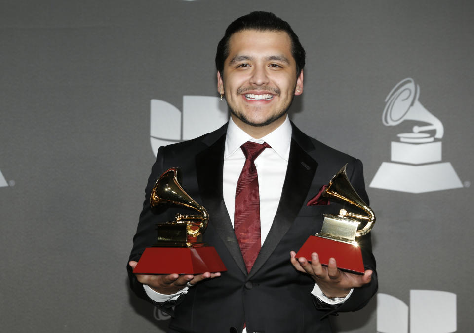 Christian Nodal poses in the press room with the awards for best ranchero/mariachi album for "Ahora" and best regional song for "No Te Contaron Mal" at the 20th Latin Grammy Awards on Thursday, Nov. 14, 2019, at the MGM Grand Garden Arena in Las Vegas. (Photo by Eric Jamison/Invision/AP)