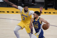 Los Angeles Lakers' Anthony Davis, left, pressures Golden State Warriors' Stephen Curry during the second half of an NBA basketball game, Monday, Jan. 18, 2021, in Los Angeles. The Warriors won 115-113. (AP Photo/Jae C. Hong)