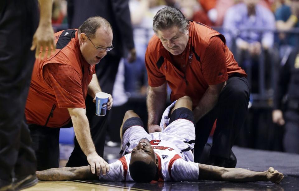 Trainers check on Louisville guard Kevin Ware after he broke his leg in 2013.