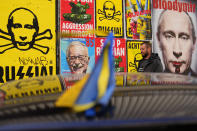 FILE - A man walks past a wall with posters depicting Russian President Vladimir Putin, in Warsaw, Poland, on Thursday, March 24, 2022. Seven decades after it was founded, the North Atlantic Treaty Organization is meeting in Madrid on June 29 and 30, 2022 with an urgent need to reassert its original mission: preventing Russian aggression against Western allies. (AP Photo/Petr David Josek, File)