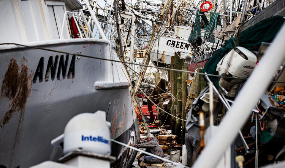 Blaine Green, a lifelong shrimper, patches holes on the shrimp boat Anna on Oct. 20, 2022. The boat was damaged in Hurricane Ian but was not destroyed. The boat went out fishing in late December.  