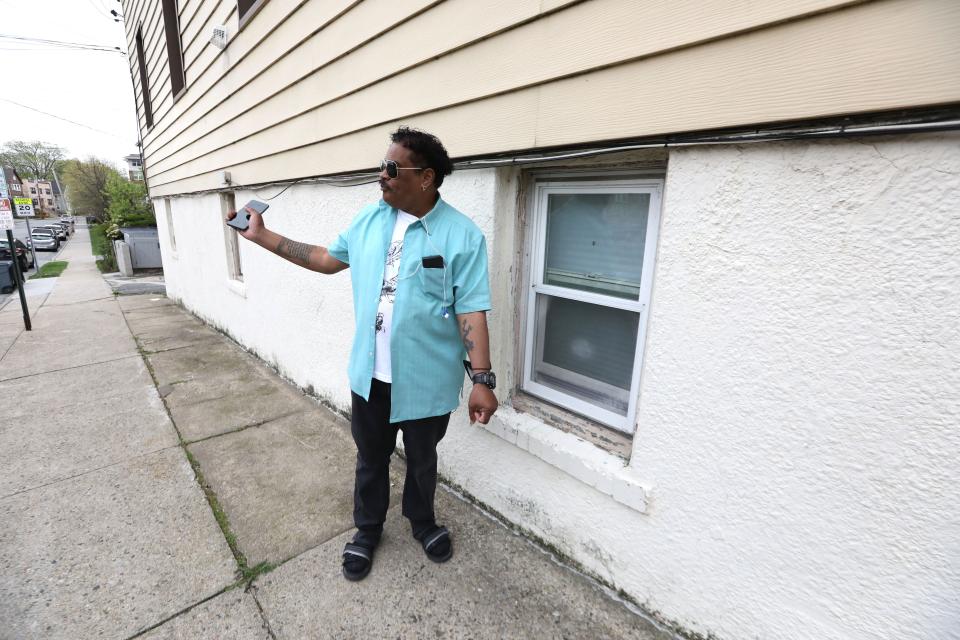Standing beside the window he escaped from, Randy Scott recounts how his block was flooded from Hurricane Ida in Mamaroneck's Flats neighborhood in New York state, May 3, 2022. Scott escaped through his kitchen window after three neighbors banged on his window to get him to leave his apartment.