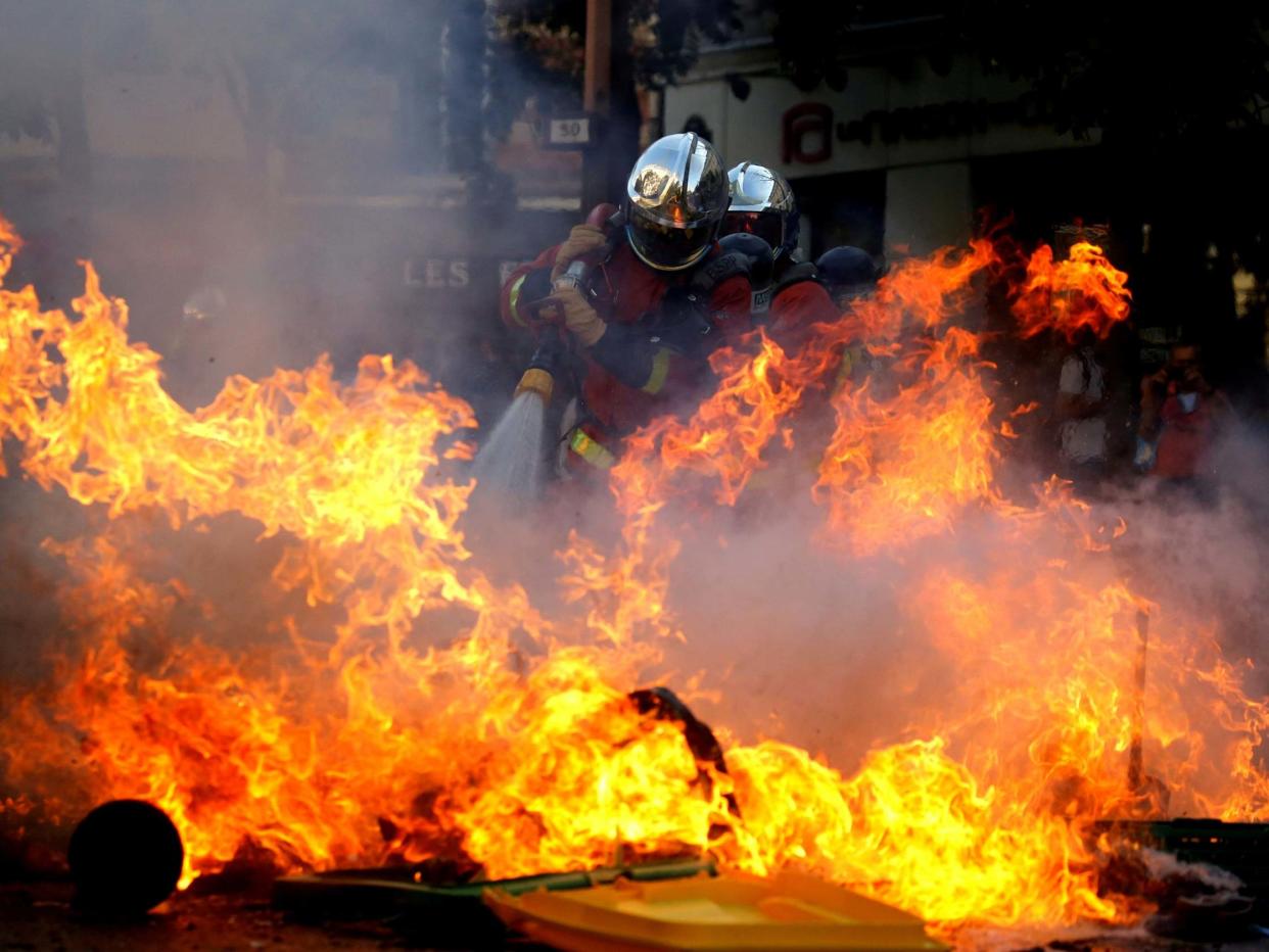 Firefighters extinguish a barricade during a protest over climate change in Paris: REUTERS