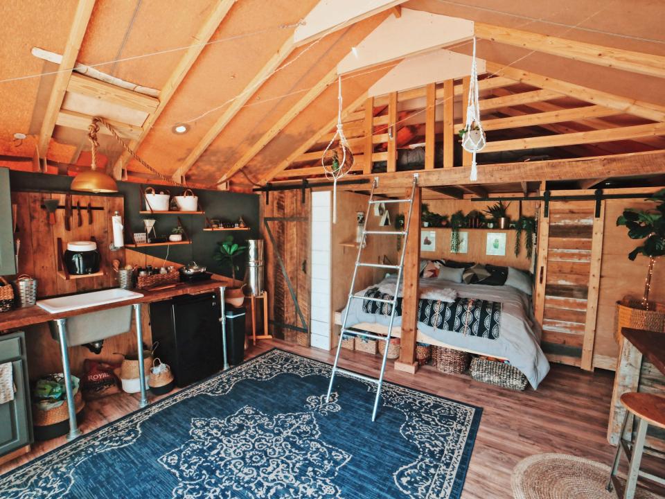 inside Zac Ruiz's tiny house tent with blue rug in the center