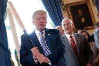 Vice President Mike Pence laughs as U.S. President Donald Trump holds a baseball bat as they attend a Made in America product showcase event at the White House in Washington, U.S., July 17, 2017. REUTERS/Carlos Barria