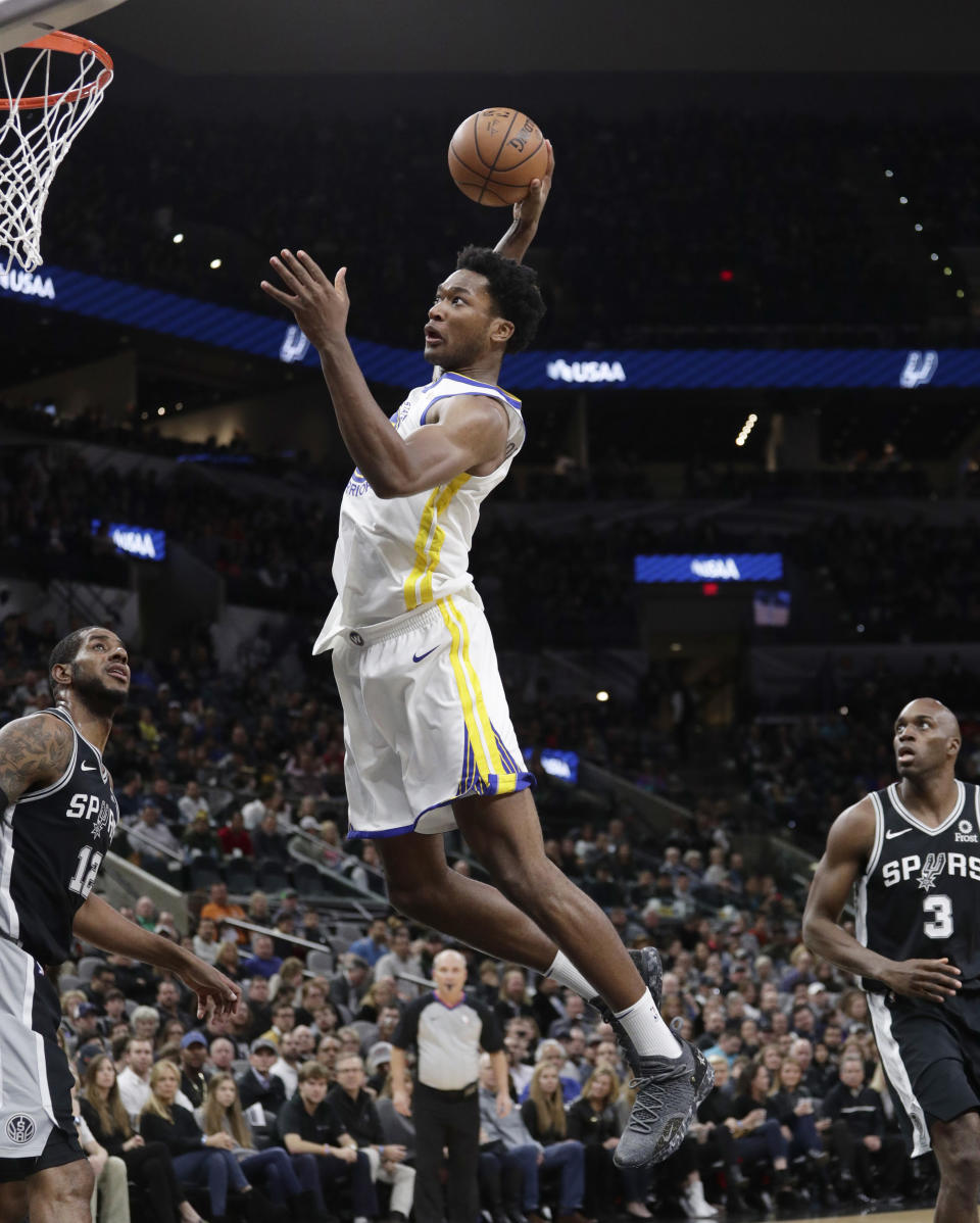 Golden State Warriors center Damian Jones (15) scores over San Antonio Spurs forward LaMarcus Aldridge (12) during the first half of an NBA basketball game, Sunday, Nov. 18, 2018, in San Antonio. (AP Photo/Eric Gay)