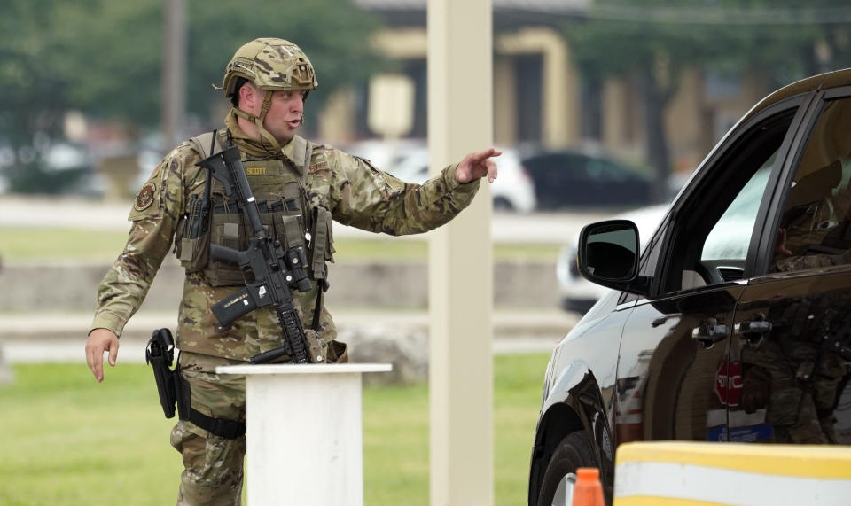 A military policeman turns away traffic at JBSA-Lackland Air Force Base game, Wednesday, June 9, 2021, in San Antonio. The Air Force was put on lockdown as police and military officials say they searched for two people suspected of shooting into the base from outside. (AP Photo/Eric Gay)