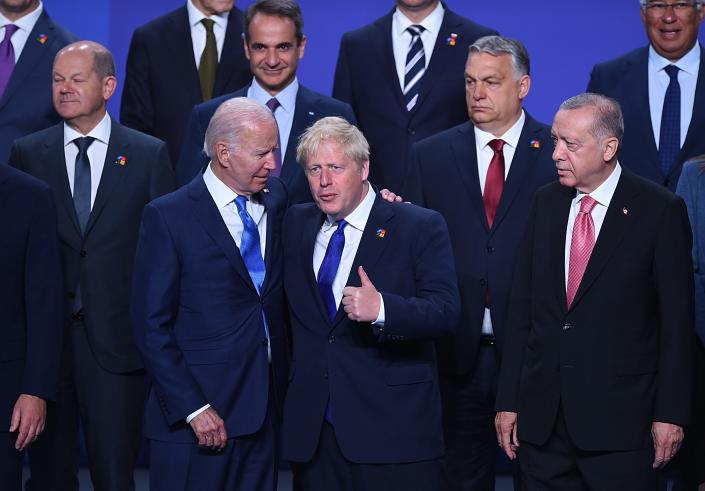 President Joe Biden ( chats with British Prime Minister Boris Johnson as Turkish President Recep Tayyip Erdogan (R) looks on during a family photo at the NATO Summit on June 29, 2022 in Madrid, Spain.