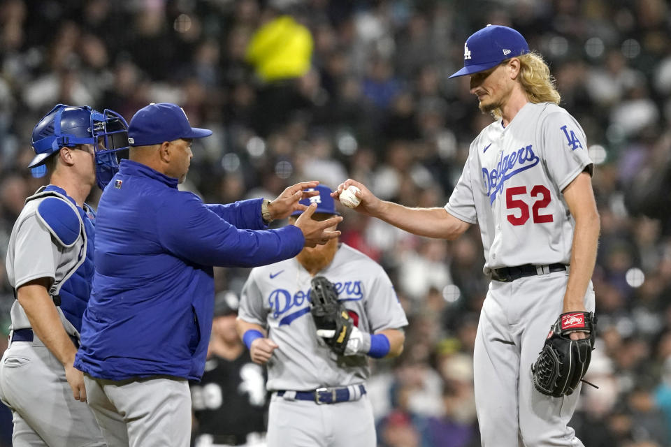 Los Angeles Dodgers manager Dave Roberts, left, pulls relief pitcher Phil Bickford during the sixth inning of the team's baseball game against the Chicago White Sox on Tuesday, June 7, 2022, in Chicago. (AP Photo/Charles Rex Arbogast)