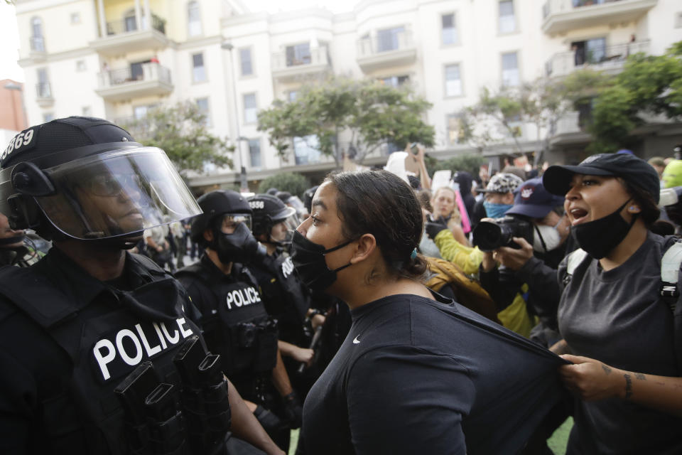 Protesters clash with police Sunday, May 31, 2020, in Santa Monica, Calif. during unrest and protests over the death of George Floyd, a black man who was in police custody in Minneapolis. Floyd died after being restrained by Minneapolis police officers on May 25. (AP Photo/Marcio Jose Sanchez)