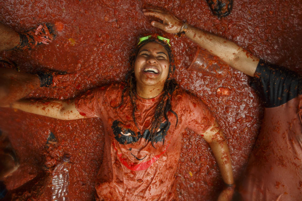 This woman looks to be in total bliss as she lays down on her back in the tomato pulp.