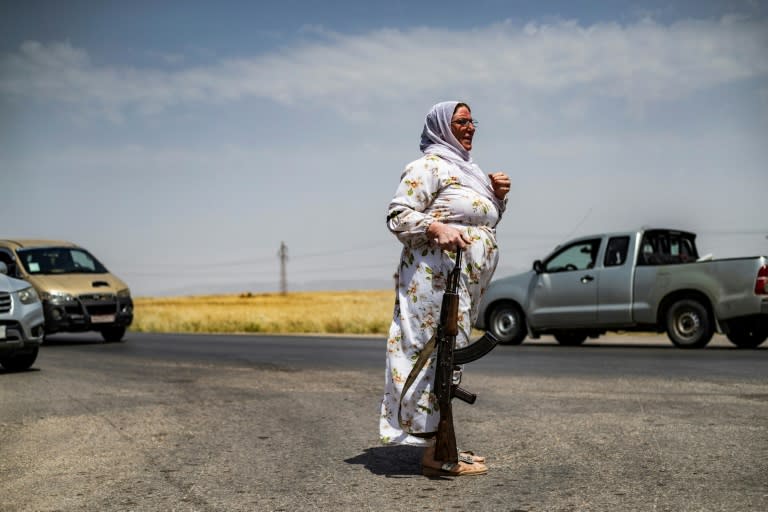 Une volontaire kurde garde un champ de blé près de la localité d'al-Qahtaniyah dans le nord-est de la Syrie, le 30 mai 2024 (Delil SOULEIMAN)