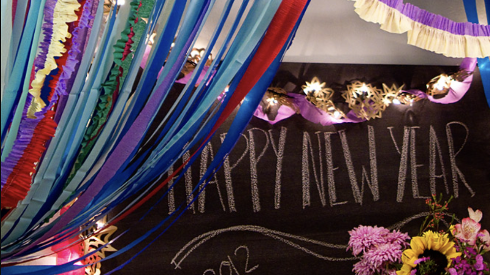 a group of colorful streamers in front of a happy new year sign