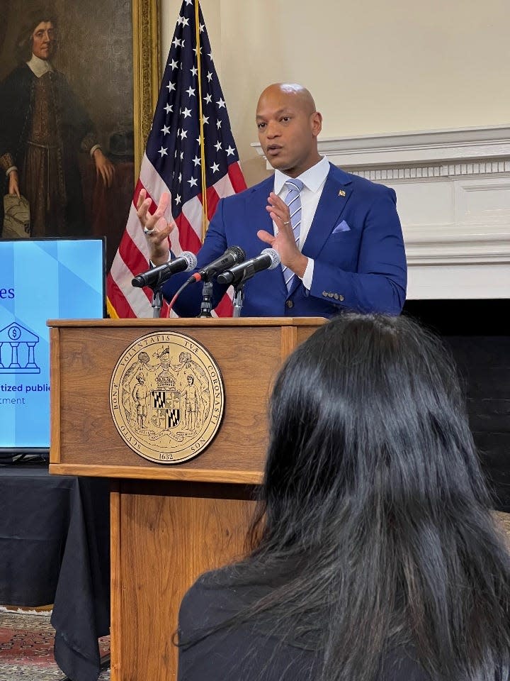 At lectern, Maryland Gov. Wes Moore, a Democrat, speaks during a press conference announcing his annual budget proposal at the State House in Annapolis on Jan. 17, 2024. In foreground, Lieutenant Gov. Aruna Miller listens to governor.