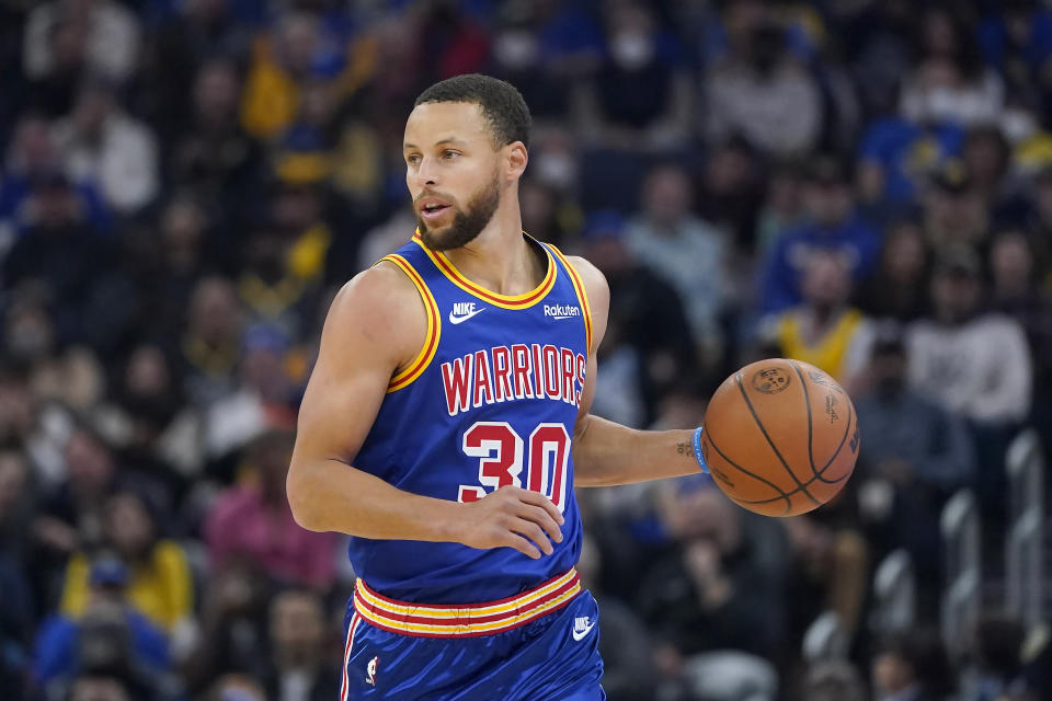 Golden State Warriors guard Stephen Curry (30) dribbles the ball upcourt against the Milwaukee Bucks during the first half of an NBA basketball game in San Francisco, Saturday, March 12, 2022. (AP Photo/Jeff Chiu)