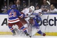 Carolina Hurricanes right wing Jesper Fast (71) battles for the puck between New York Rangers defensemen Ryan Lindgren (55) and Adam Fox (23) during the second period of Game 3 of an NHL hockey Stanley Cup second-round playoff series, Sunday, May 22, 2022, in New York. (AP Photo/Adam Hunger)