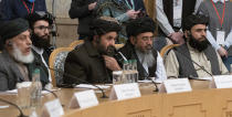 FILE - In this March 18, 2021, file photo, Taliban co-founder Mullah Abdul Ghani Baradar, center, with other members of the Taliban delegation attends an international peace conference in Moscow, Russia. U.S.-backed Afghan peace meeting postponed, as Taliban balk a conference that Washington expected would move Afghanistan's warring sides to a final peace agreement has been postponed, as fresh violence rattles the Afghan capital, Wednesday, April 21, 2021. (AP Photo/Alexander Zemlianichenko, Pool, File)