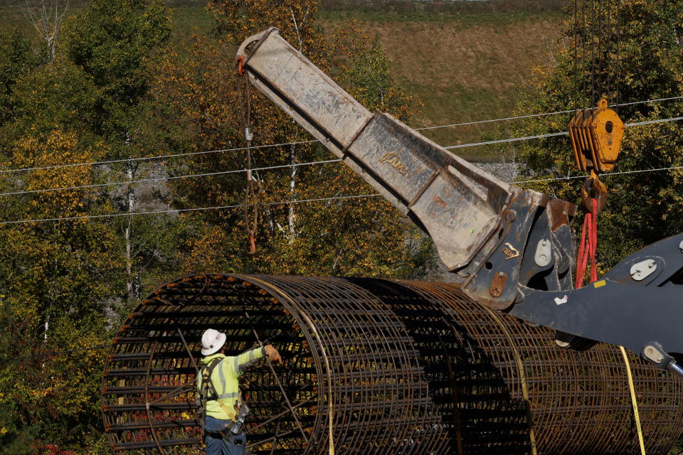 Workers install the footing for a new pole for transmission lines for the New England Clean Energy Connect project which will bring hydroelectric power to the New England power grid, in Moscow, Maine, October 7, 2021. REUTERS/Brian Snyder