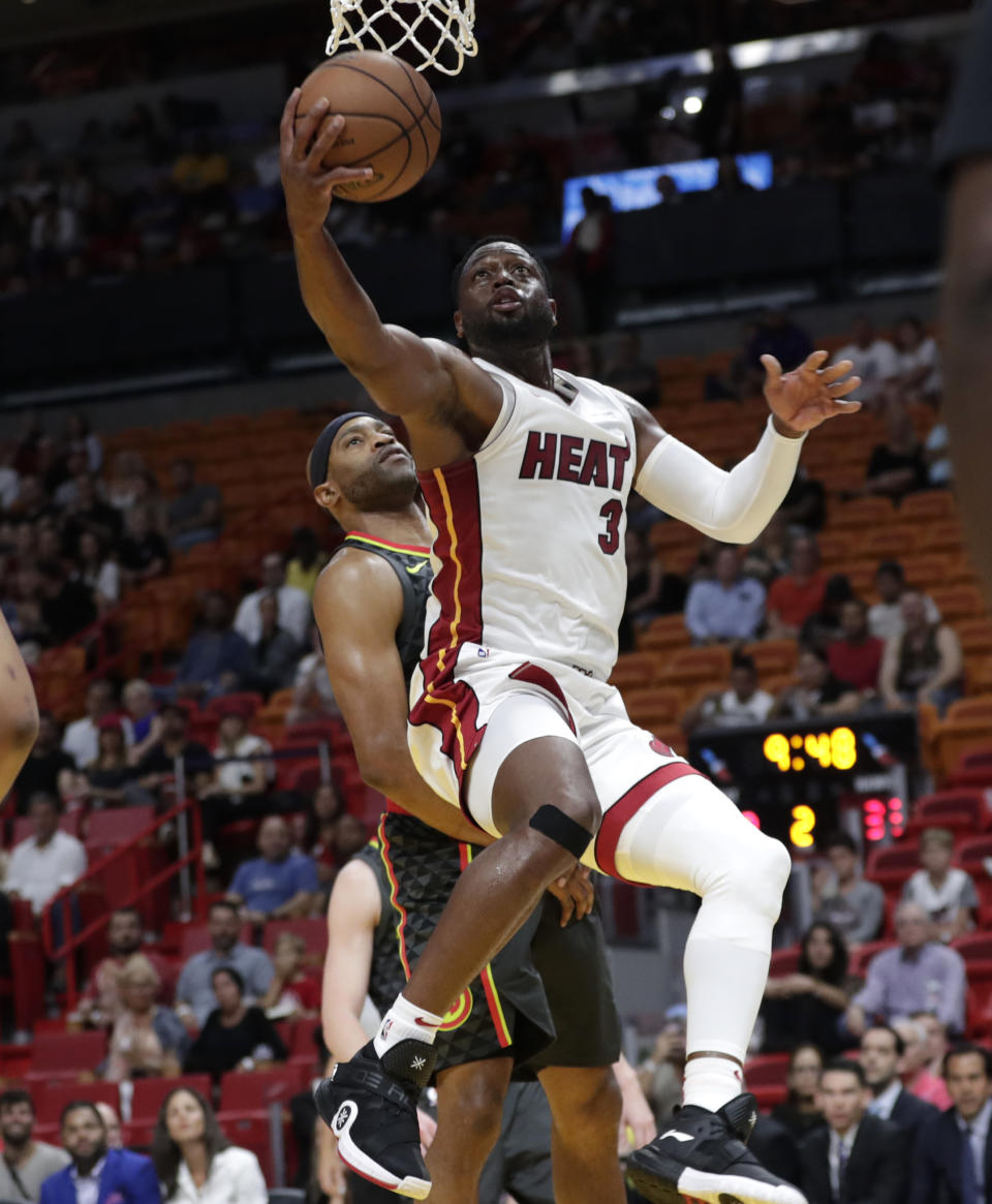 Miami Heat's Dwyane Wade (3) drives past Atlanta Hawks' Vince Carter during the first half of a preseason NBA basketball game, Friday, Oct. 12, 2018, in Miami. (AP Photo/Lynne Sladky)
