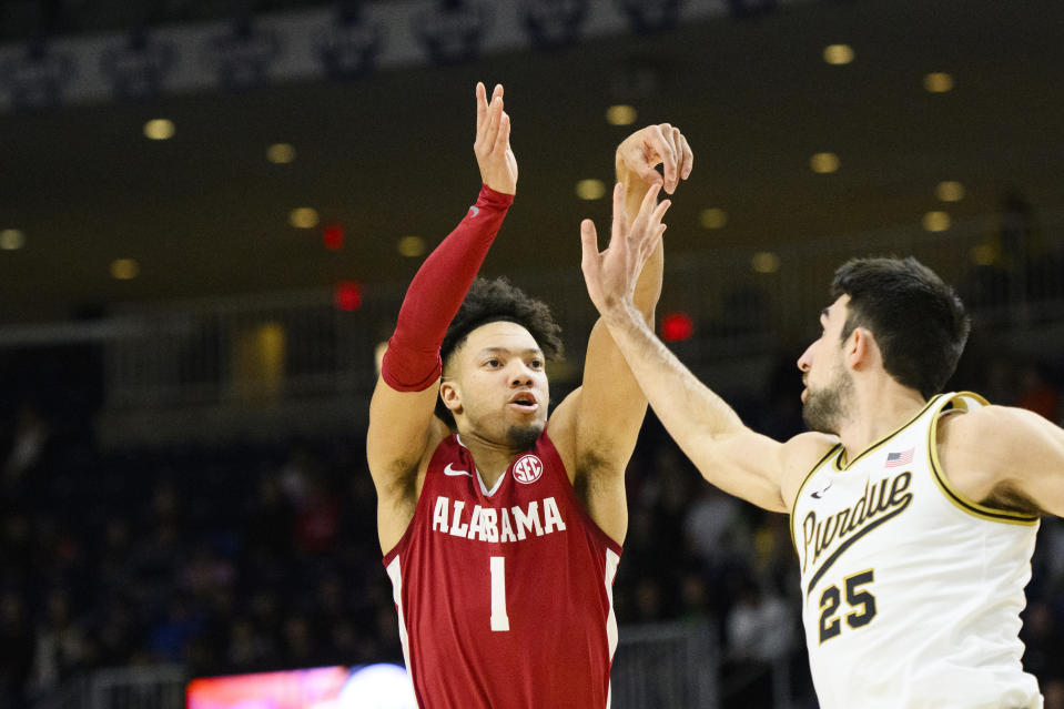 Alabama guard Mark Sears (1) shoots a 3-pointer while defended by Purdue guard Ethan Morton (25) during the first half of an NCAA college basketball game in Toronto, Saturday, Dec. 9, 2023. (Christopher Katsarov/The Canadian Press via AP)