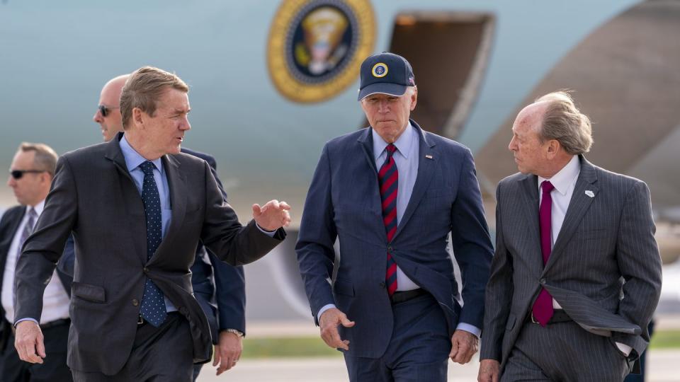 Air Force One is visible as President Joe Biden, center, speaks with by Sen. Michael Bennet, D-Colo., left, and Colorado Springs Mayor John Suthers, right, as he arrives at Peterson Space Force Base in Colorado Springs, Colo., Wednesday, May 31, 2023. (Andrew Harnik/AP)