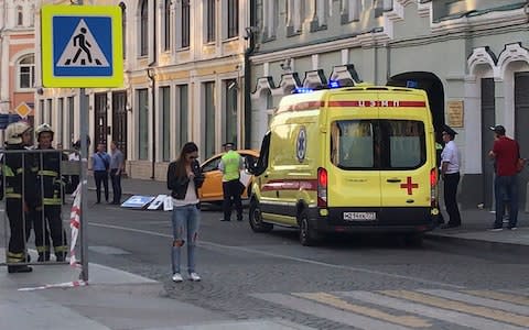 An ambulance parked near the damaged taxi that injured seven when it mounted the pavement  - Credit: Jack Stubbs/Reuters