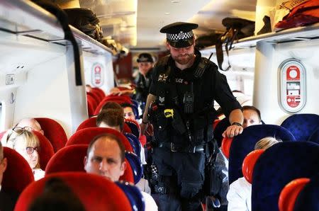 Armed police officers walk along the aisle of a train at Milton Keynes station, Britain May 25, 2017. REUTERS/Neil Hall