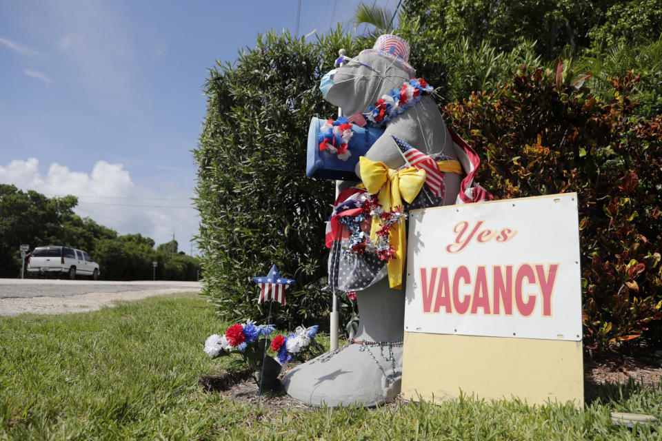 A mailbox in the shape of a manatee wears a protective face mask outside of the Island Bay Resort in Tavernier, in the Florida Keys, during the new coronavirus pandemic, Monday, June 1, 2020. The resort is open for guests as the Florida Keys reopened for visitors Monday after the tourist-dependent island chain was closed for more than two months to prevent the spread of the coronavirus. (AP Photo/Lynne Sladky)