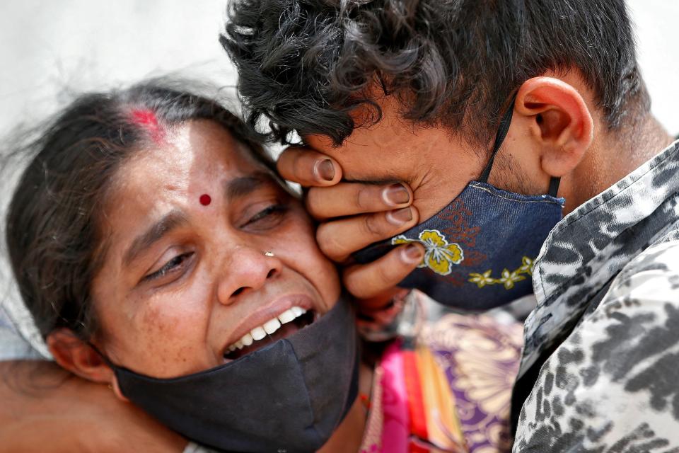 A woman in India mounrs her husband following his death due to CovidREUTERS