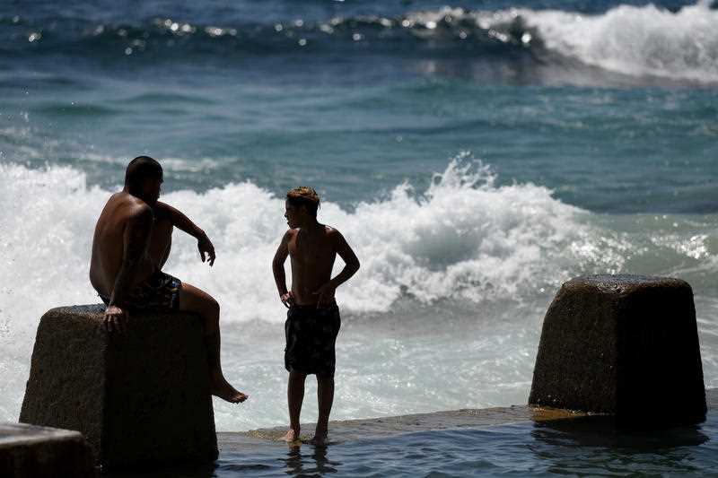 Beachgoers are seen at Ross Jones Rockpool in Coogee during hot weather in Sydney.