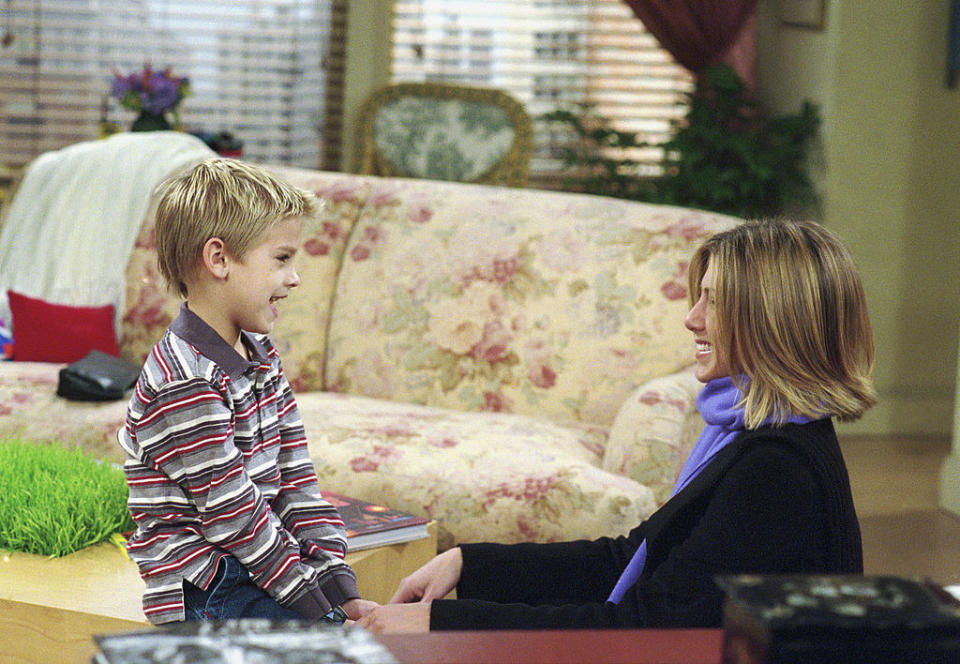 A young Cole and Jennifer smiling at each other