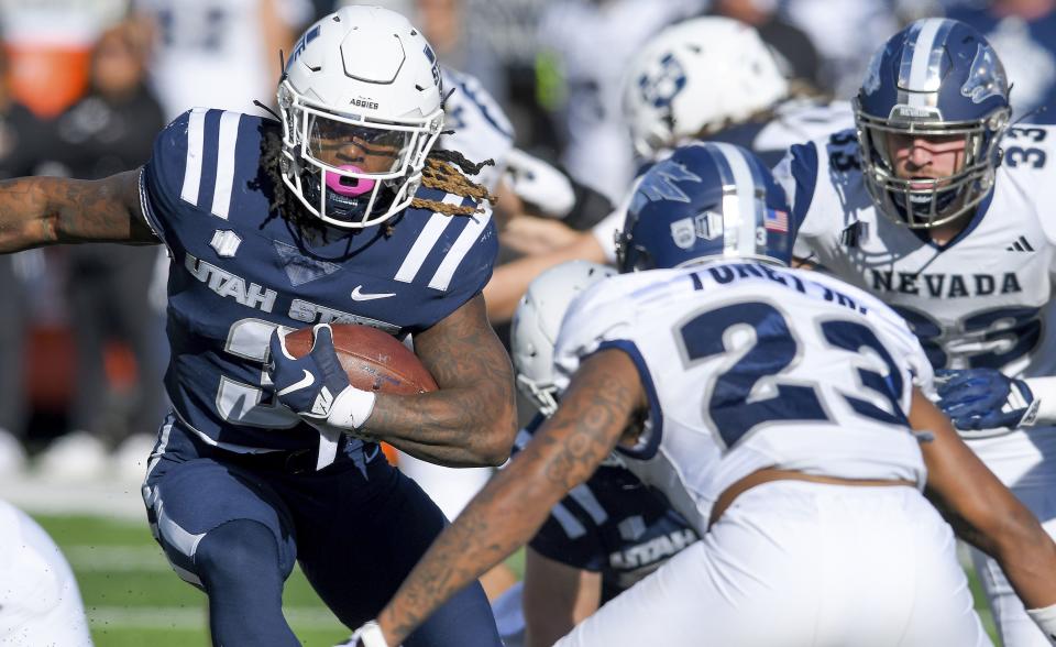 Utah State running back Rahsul Faison, left, carries the ball as Nevada defensive back Richard Toney Jr. (23) defends during the first half of an NCAA college football game Saturday, Nov. 11, 2023, in Logan, Utah. | Eli Lucero/The Herald Journal via AP