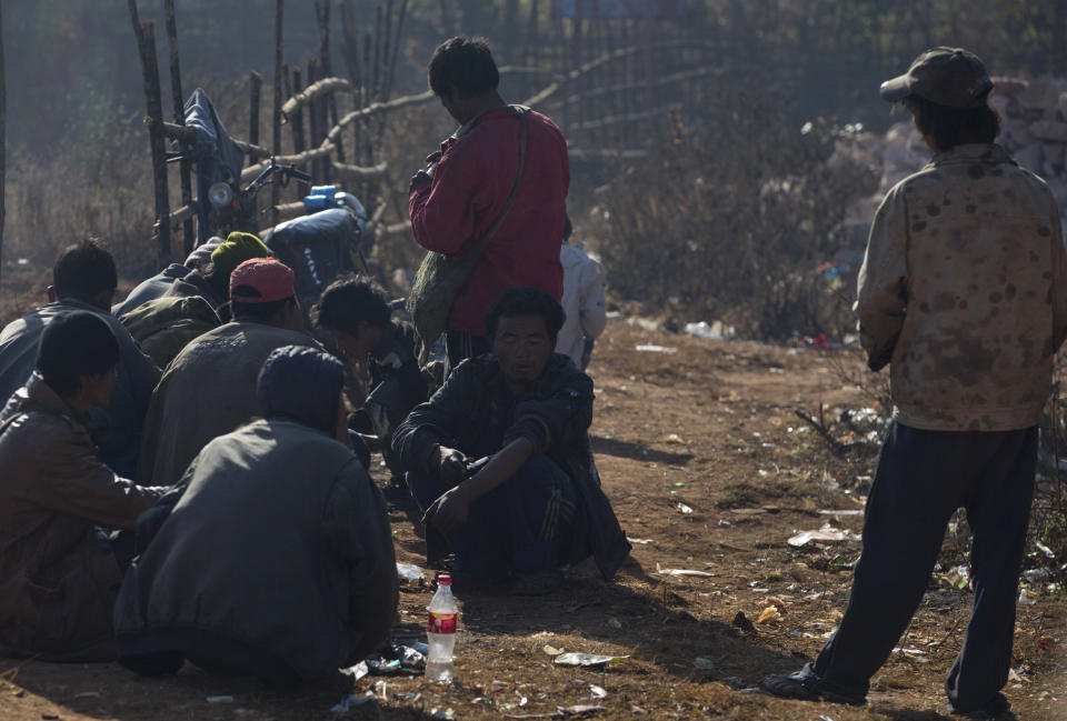 In this Jan 28, 2014 photo, addicts are surrounded by discarded dirty needles and syringes at a cemetery in Nampatka village, northeastern Shan State, Myanmar. Every morning, more than 100 heroin and opium addicts descend on the graveyard to get high. Some junkies lean on white tombstones, tossing dirty needles and syringes into the dry, golden grass. Others squat on the ground, sucking from crude pipes fashioned from plastic water bottles. (AP Photo/Gemunu Amarasinghe)