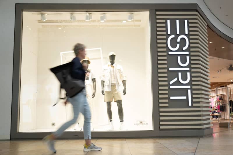 A passer-by walks in front of a branch of the fashion group Esprit. The global fashion retailer Esprit plans to close all of its 56 shops in Germany by the end of the year. Sebastian Kahnert/dpa