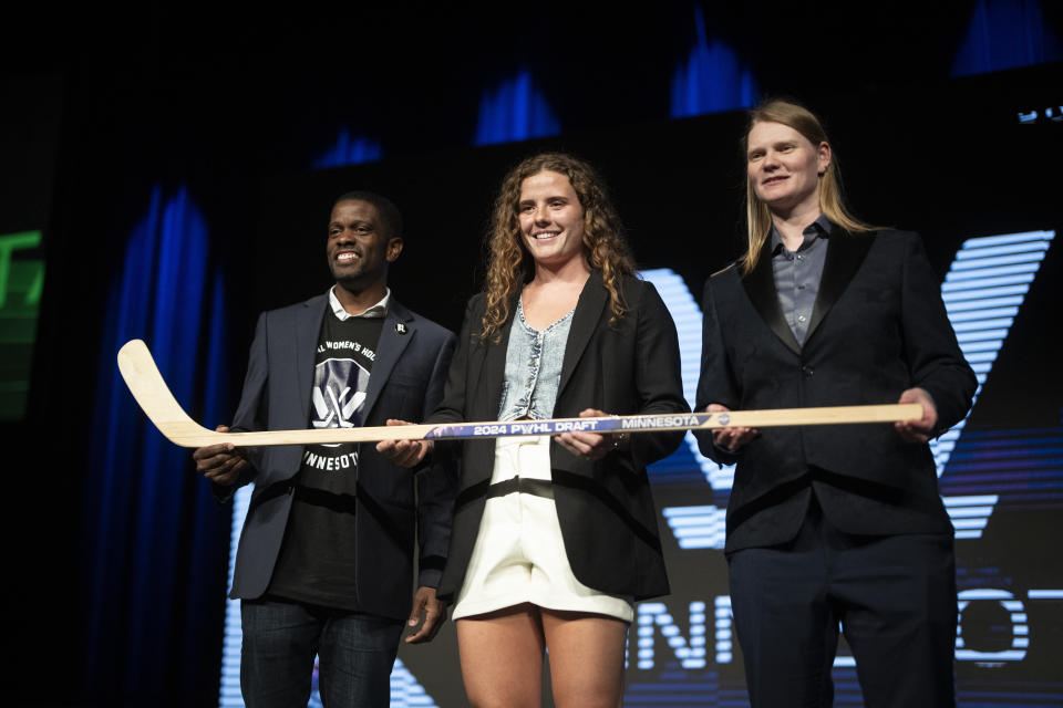 PWHL Minnesota second round draft pick Britta Curl, center, poses for a photo with Minnesota assistant coach Mira Jalosuo, right, and St. Paul Mayor Melvin Carter during the PWHL hockey draft in St. Paul, Minn., on Monday June, 10, 2024. (Renée Jones Schneider/Star Tribune via AP)