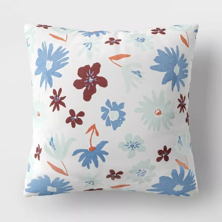 the pillow with a blue, maroon, and orange floral pattern