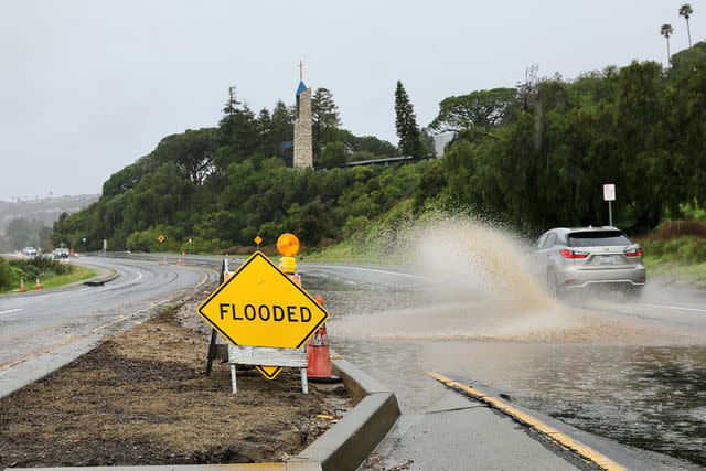 <p>Xinhua via Getty</p> A flooded road near Wayfarers Chapel on Feb. 20, 2024