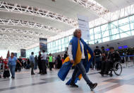 Un fanático de Boca Juniors camina con la bandera del equipo sobre sus hombros antes de partir a España para asistir a la final de la Copa Libertadores contra River Plate, en el aeropuerto de Ezeiza en Buenos Aires, Argentina, 6 de diciembre de 2018. REUTERS / Marcos Brindicci