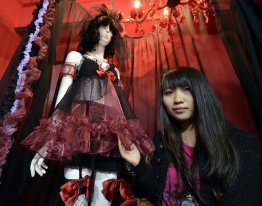 Maiko Fujii, who studies the Lolita style at Tokyo-based Vantan Design Institute, stands next to her interpretation of Snow White, decked out in a camisole with dark red chiffon and black knee-high stockings
