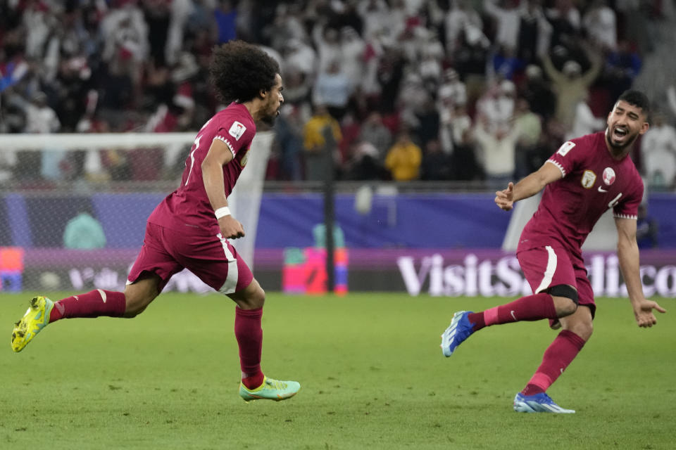 Qatar's Akram Afif, left, celebrates after scoring his side's second goal during the Asian Cup semifinal soccer match between Iran and Qatar at Al Thumama Stadium in Doha, Qatar, Wednesday, Feb. 7, 2024. (AP Photo/Aijaz Rahi)