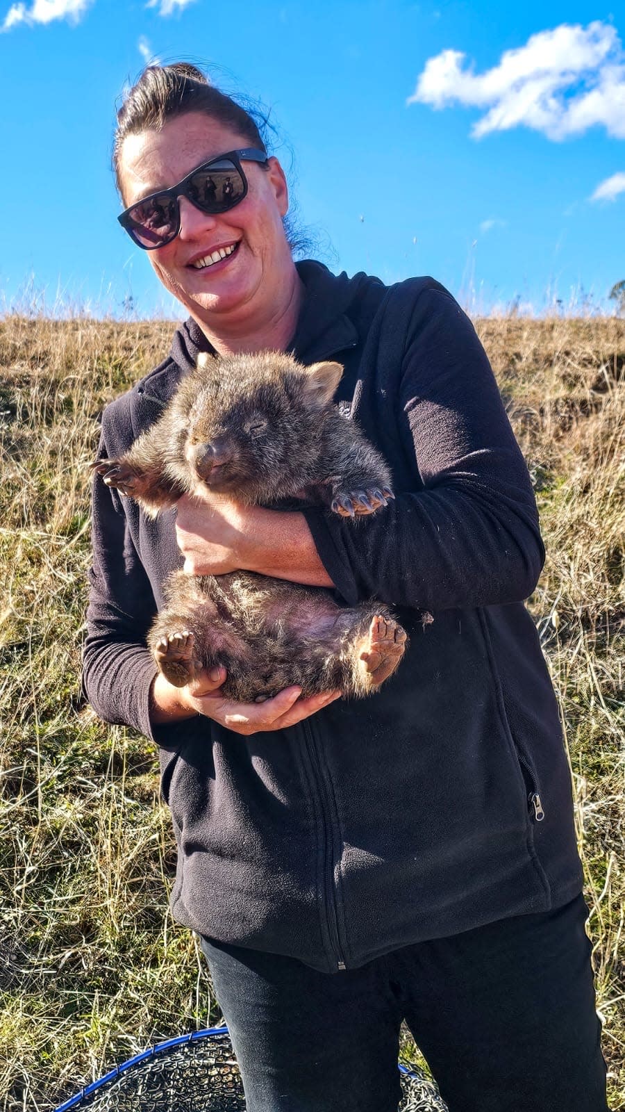 Yolandi Vermaak holding the tiny wombat in the horse paddock in Canberra.