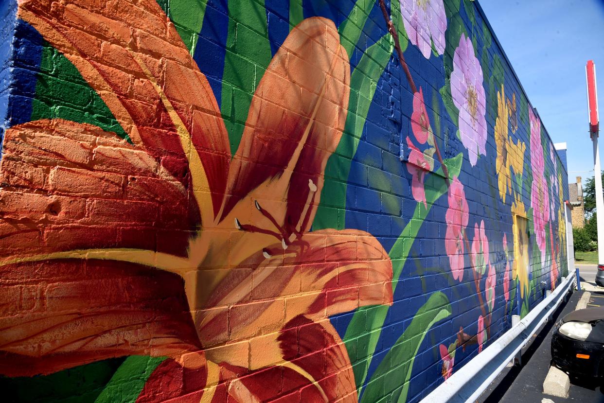 Artist Ouizi (Louise Jones) crafted this flower and butterfly mural for Tiffany's Pizza in Monroe last summer as part of the first year of the PLNTNG SEEDS Initiative.