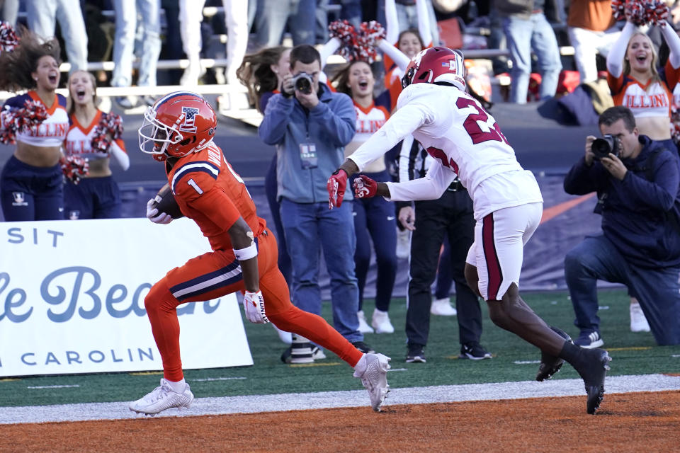 Illinois wide receiver Isaiah Williams, left, scores the game winning touchdown as Indiana defensive back Jamari Sharpe defends during the overtime period of an NCAA college football game Saturday, Nov. 11, 2023, in Champaign, Ill. Illinois won 48-45. (AP Photo/Charles Rex Arbogast)